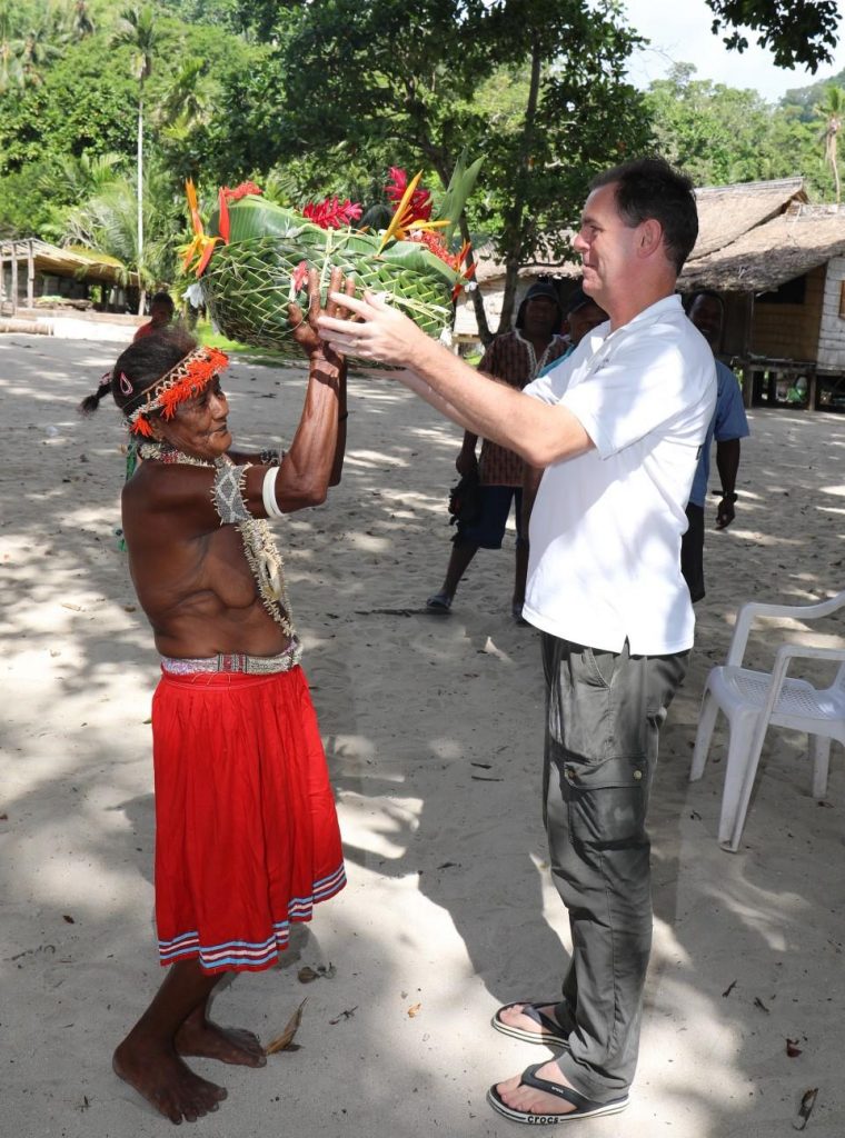 Commissioner of Lands Allan McNeil recieves a gift from a woman at Olevuga
