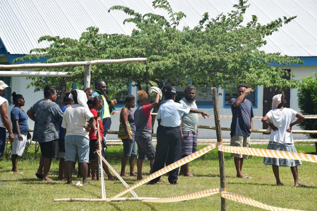 A female police officer controls voters at the GPPOL 3 polling station in the NE Guadalcanal constituency