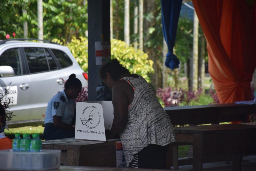 A female voter prepares to cast her ballot paper at the Komuvatha polling station in the NE Guadalcanal Constituency