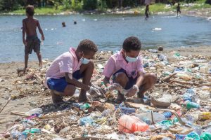 Photo 3 Two of the school children picking up plastic waste during day one of the workshop.