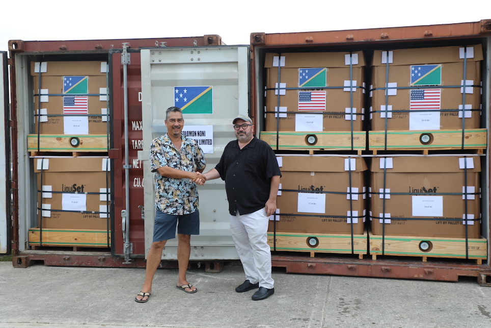 OFF TO THE USA; US Chargé d’affaires Russel Comeau acknowledged Caretaker MP for Northwest Guadalcanal Bodo Dettke as they witness 40tons of noni bound for Los Angeles, California