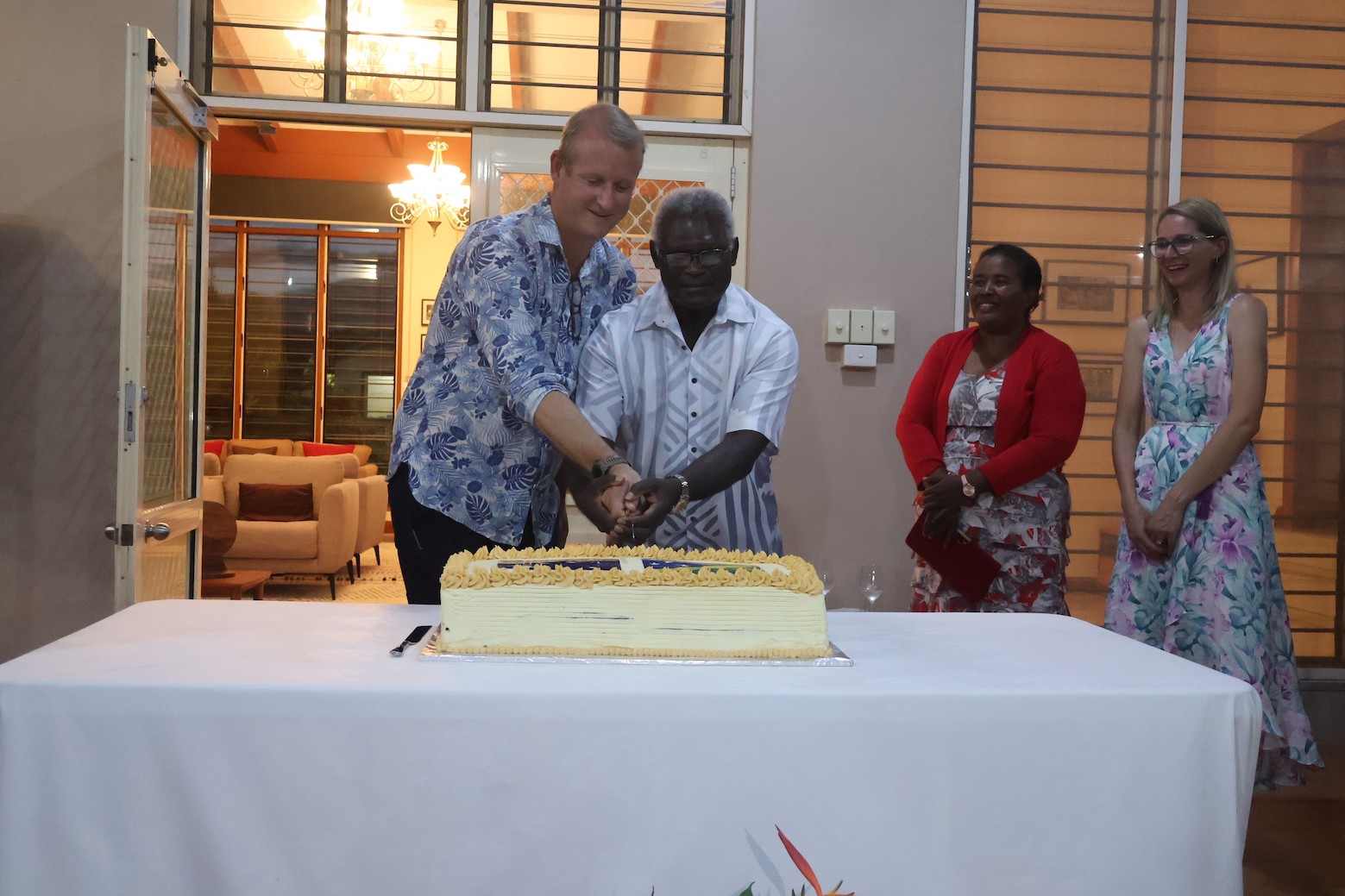 Caretaker PM Sogavare and AHC H.E Hilton cutting the Australian Day Cake. On the right are Madam Emmy Sogavare and Ms. Ewa Janus